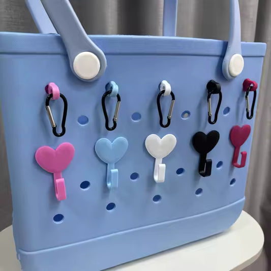 Blue pegboard with heart-shaped hooks attached to it.